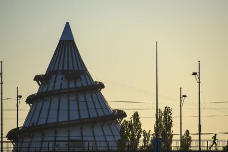 Ein Jogger überquert am frühen Morgen die Brücke des Friedens und läuft am Jahrtausendturm in Magdeburg vorbei. 