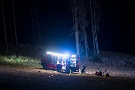 Die Feuerwehr überwacht am Waldrand Glutnester nach einem Waldbrand in einem Waldstück der Saalfelder Höhe.