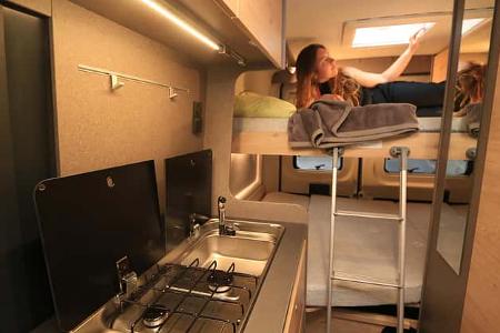 Globetrail 600 SK Campingbus mit Stockbetten im Heck, Person im oberen Stockbett