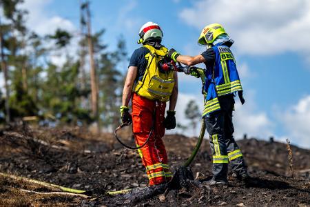 Mit Löschrucksäcken gehen die Feuerwehrleute etwa gegen Glutnester vor. 