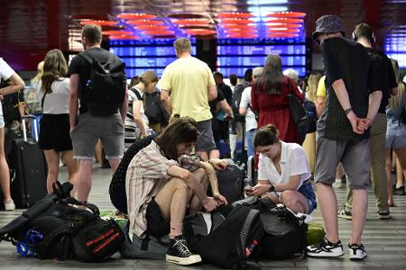 Passagiere sitzen in der Halle des Prager Hauptbahnhofs während eines Stromausfalls. 