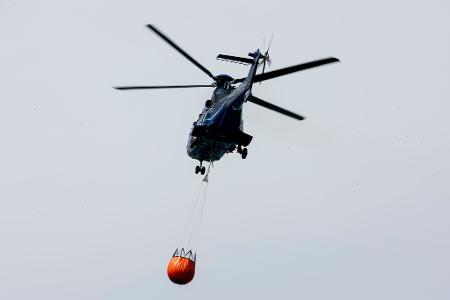 Ein Löschhubschrauber der Bundespolizei fliegt über dem Zeithainer Tagebau und nimmt Wasser auf, um den Waldbrand Gohrischheide zu bekämpfen. Ein Löschhubschrauber der Bundespolizei fliegt über dem Zeithainer Tagebau und nimmt Wasser auf, um den Waldbrand Gohrischheide zu bekämpfen.