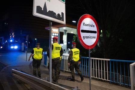 Polnische Grenzschützer gehen über die Stadtbrücke von Görlitz in Richtung Polen. 