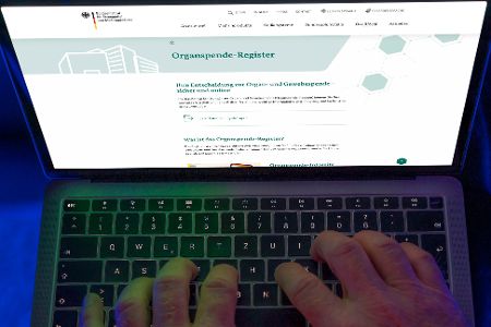 User sitzt vor Laptop, auf dem das Organspende-Register zu sehen ist