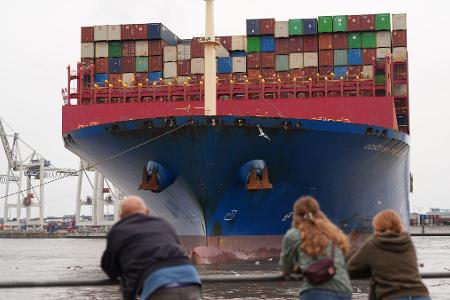 Passanten verfolgen das Anlegemanöver des riesigen Containerschiffs „Cosco Shipping Virgo“ der Reederei Cosco Shipping im Hamburger Container-Terminal Tollerort.