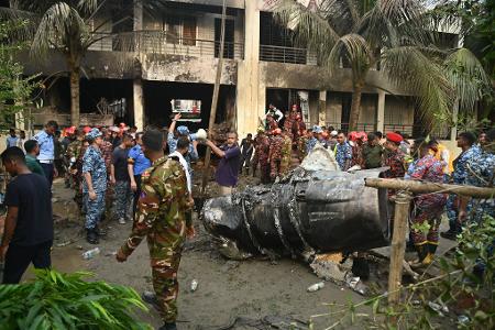 Rettungskräfte am Ort des Absturzes eines Militärjets in Dhaka. Rettungskräfte am Ort des Absturzes eines Militärjets in Dhaka.