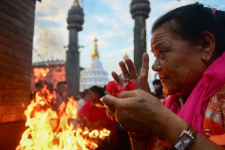 Eine Frau betet im Tempelkomplex Swayambhunath während Gunla, dem heiligen zehnten Monat des nepalesischen Sambat-Kalenders.