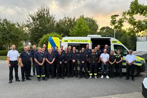 "Führungskräfte der Freiwilligen Feuerwehr Bedburg-Hau im Austausch mit dem VU-Team der Kreispolizeibehörde Kleve - im Hintergrund das speziell ausgerüstete Einsatzfahrzeug für die Verkehrsunfallaufnahme."