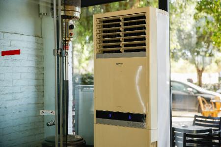Athen: Eine mobile Klimaanlage steht im verglasten Innenraum eines Cafés. (Archivbild)