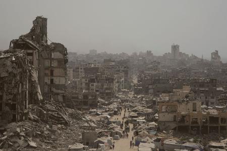 Menschen gehen auf zerstörter Straße im Gazastreifen. (Archivbild)