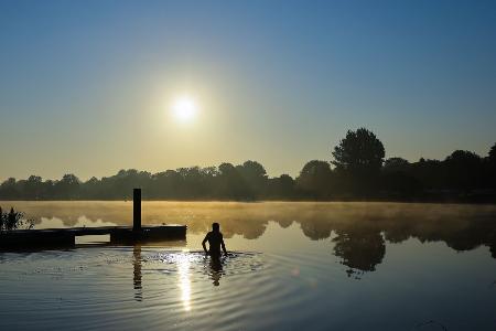 Ein Mann geht am frühen Morgen in der Eider schwimmen.