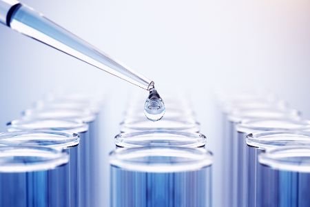 Pipette füllt Flüssigkeit in ein Reagenzglas