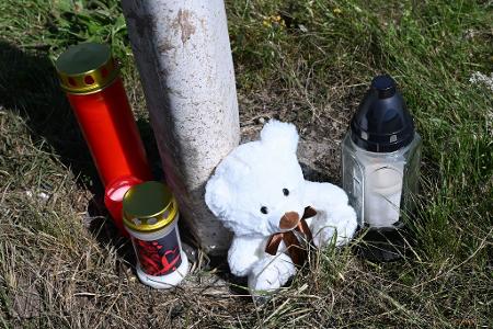 Menschen haben Kerzen und einen Teddybären an der Unfallstelle abgestellt.