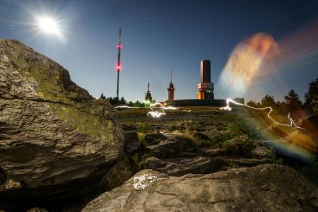 Menschen sind um Mitternacht mit Taschenlampen auf dem Feldberg-Plateau unterwegs und hinterlassen bei der Langzeitbelichtung Lichtreflexe. Der Ansturm auf den Hausberg im Rhein-Main-Gebiet wird in der Nacht von Dienstag auf Mittwoch (12. auf 13. August) vermutlich sehr groß sein. Der Sternschnuppen-Strom der Perseiden über Deutschland wird seinen Höhepunkt erreichen und lässt sich von der höchsten Erhebung im Taunus gut beobachten.