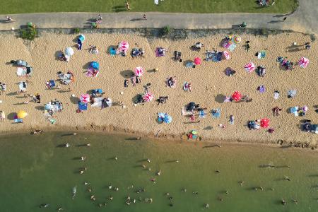 Badegäste liegen am Strand am Rather See in Köln (Luftaufnahmen mit einer Drohne).