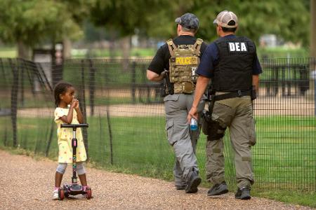 Ein Kind beobachtet, wie Beamte der Drug Enforcement Administration entlang der National Mall in Washington patrouillieren.