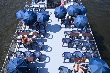 Beschirmt gegen die Sonne - Touristen auf der Spree