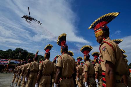 Ein Hubschrauber der indischen Luftwaffe wirft in Guwahati Blüten ab, während Angehörige der Polizei von Assam an einer Parade der Feierlichkeiten zum Unabhängigkeitstag teilnehmen. Der Unabhängigkeitstag Indiens wird jährlich am 15. August begangen.