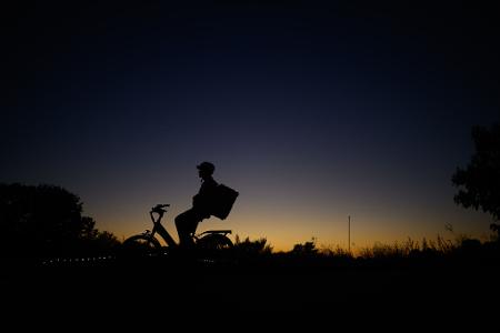 Ein Fahrradfahrer ist am Abend nach dem Sonnenuntergang auf dem Elberadweg an der Hafencity in Dresden unterwegs.