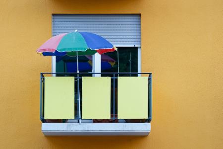 Urlaub auf Balkonien: Mit einem bunten Sonnenschirm werden auch zwei Quadratmeter zum Ort der Entspannung. 