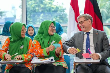 Außenminister Johann Wadephul scherzt bei seinem Besuch in Indonesien in einer Fachschule für Gesundheitsberufe mit Studentinnen.