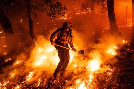 Flammen des Pickett-Feuers umzingeln einen Feuerwehrmann in Kalifornien.