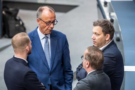 Versöhnliche Tonlage: Kanzler Merz spricht mit SPD-Generalsekretär Klüssendorf (links) und SPD-Chef Klingbeil (ganz rechts) im Bundestag. (Archivbild)