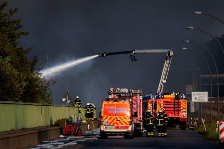 Einsatzkräfte der Feuerwehr versuchen, einen Brand in einem Industriegebiet im Hamburger Hafen zu löschen.