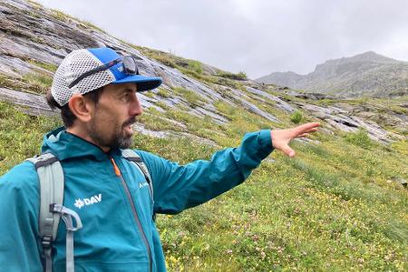 Der DAV-Geowissenschaftler Tobias Hipp zeigt auf die Vegetation - hier war früher Gletscher. 