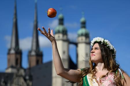 Die Blütenkönigin Alida I. jongliert mit einem Apfel zu Eröffnung der Apfelsaison in Halle (Saale).