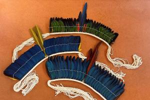 Die aus Brasilien stammenden Federkronen wurden aus artgeschützten Papageienfedern gefertigt. Der Zoll entdeckte die nicht einfuhrfähige Ware in einem Postpaket. Die Federkronen wurde beschlagnahmt und gegen die Empfängerin ein Ermittlungsverfahren eingeleitet. Bildquelle: Zollverwaltung