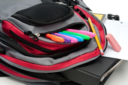 Offener Schulrucksack, aus dem Filzstifte hervorschauen