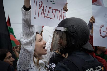Eine junge Frau protestiert vor einem Polizisten während einer Kundgebung in Spanien bei der Vuelta a España gegen den Gaza-Krieg.