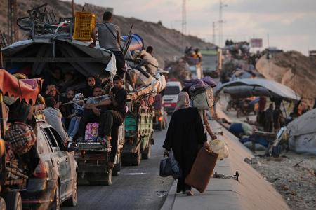 Vertriebene Palästinenser, die aus dem nördlichen Gazastreifen fliehen, tragen ihre Habseligkeiten entlang der Küstenstraße in Richtung des südlichen Gazastreifens.