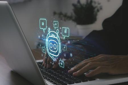 Ein Mann ruft mit seinem Laptop einen Chatbot auf