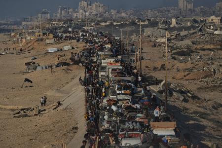 Vertriebene Palästinenser fliehen zu Fuß und in Fahrzeugen aus dem nördlichen Gazastreifen und tragen ihre Habseligkeiten entlang der Küstenstraße in Richtung des südlichen Gazastreifens.