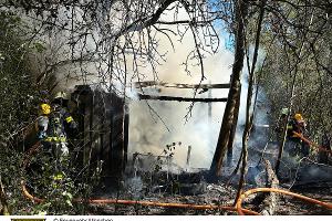 Zwei Feuerwehrmänner beim löschen der Gartenhütte.