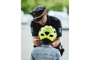 Polizist setzt einem Kind einen Fahrradhelm auf.
Quelle: Thüringer Polizei