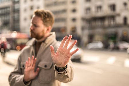 Mann streckt die ablehnend die Hände hoch