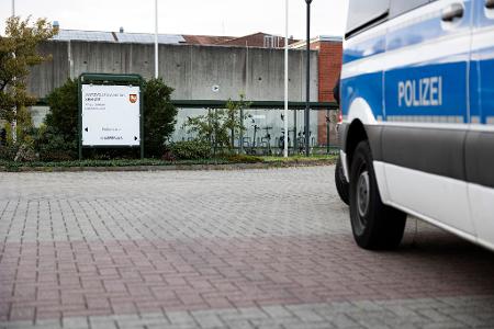 Ein Mannschaftswagen steht vor der JVA. 