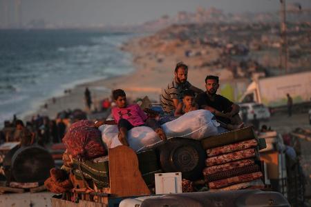 Vertriebene Palästinenser fliehen aus Gaza und tragen ihre Habseligkeiten entlang der Küstenstraße in Richtung des südlichen Gazastreifens.