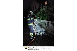 Ein Feuerwehrmann der Feuerwehr München löscht eine brennende Matratze.