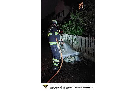 Ein Feuerwehrmann der Feuerwehr München löscht eine brennende Matratze.