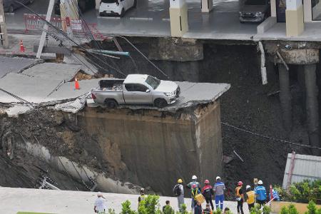 Der Weg ist weg. In Bangkok ist eine Straße eingestürzt und dieser Pickup steht deshalb plötzlich an einem Abgrund. 