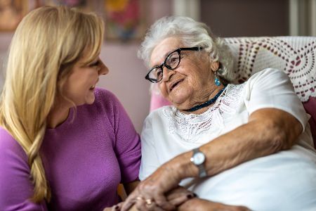 Junge Frau kümmert sich um alte Frau