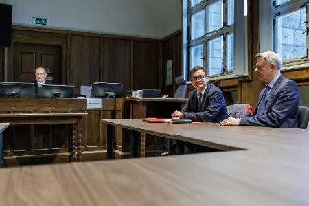 Kay Gottschalk (AfD, M), Bundestagsabgeordneter, sitzt mit Anwalt Michael Zischka (r) und Richter Burkhard Niebisch (hinten l) im Gerichtssaal.