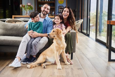 Familie mit Hund sitzt auf einer Couch
