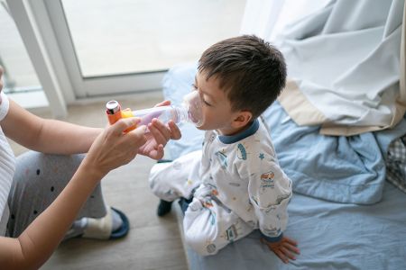 Kleines Kind mit einer Asthmamaske auf, bekommt eine Inhalation