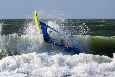 Der französische Windsurfer Antoine Martin stürzt nach einem Sprung im Shorebreak während des Windsurf World Cups auf Sylt.