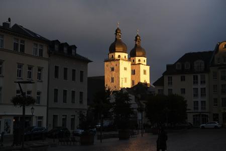 Die Türme der Johanniskirche in Plauen werden von der untergehenden Sonne beschienen.